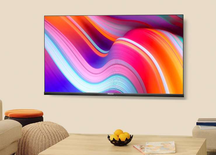 una tv appesa al muro e un divano