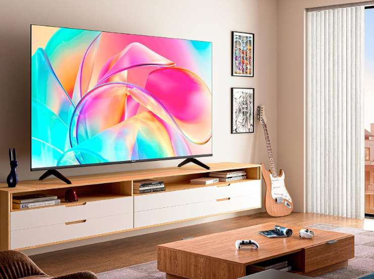 Una tv su un mobile con uno sfondo coloratissimo
