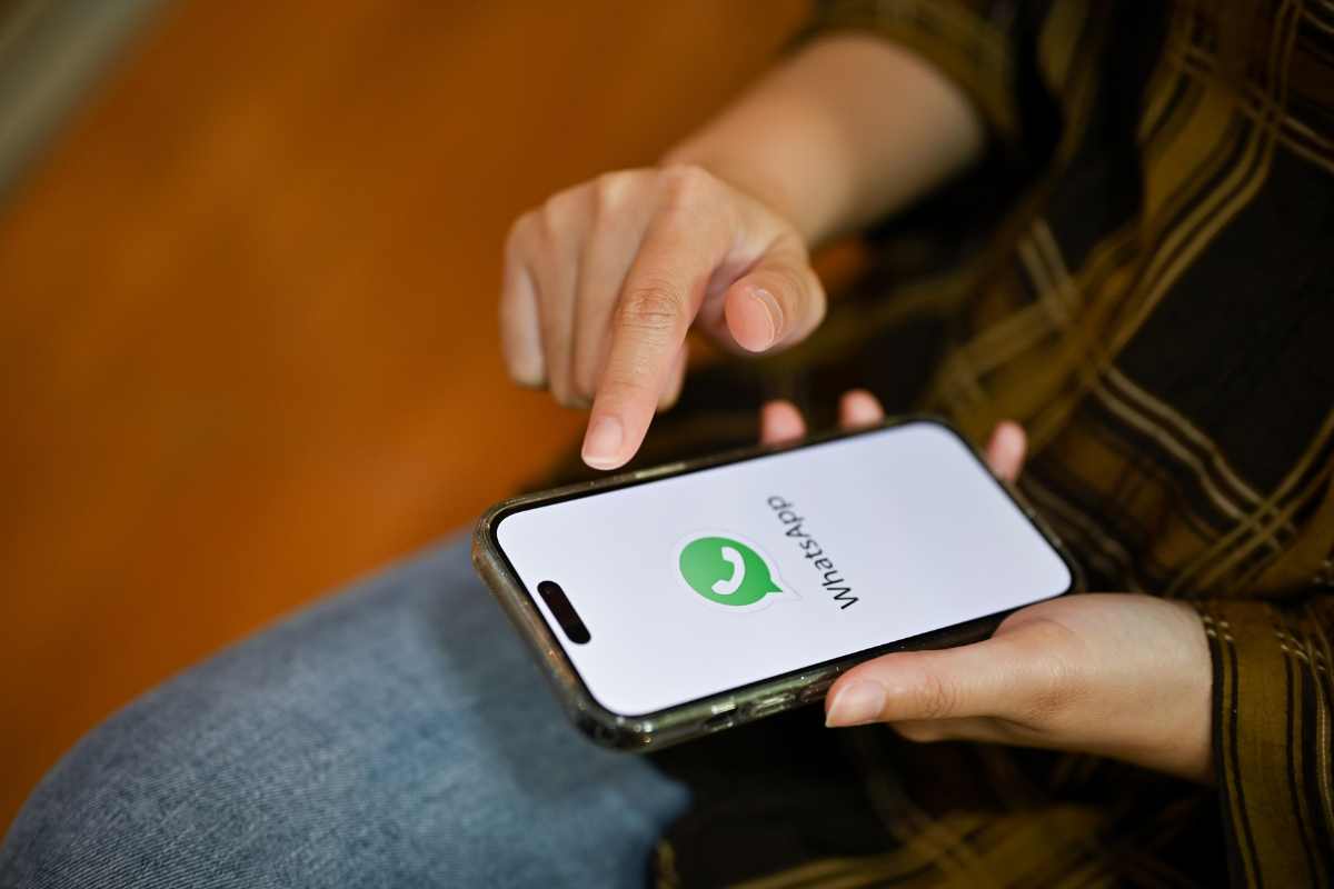 mano che usa whatsapp su un telefono
