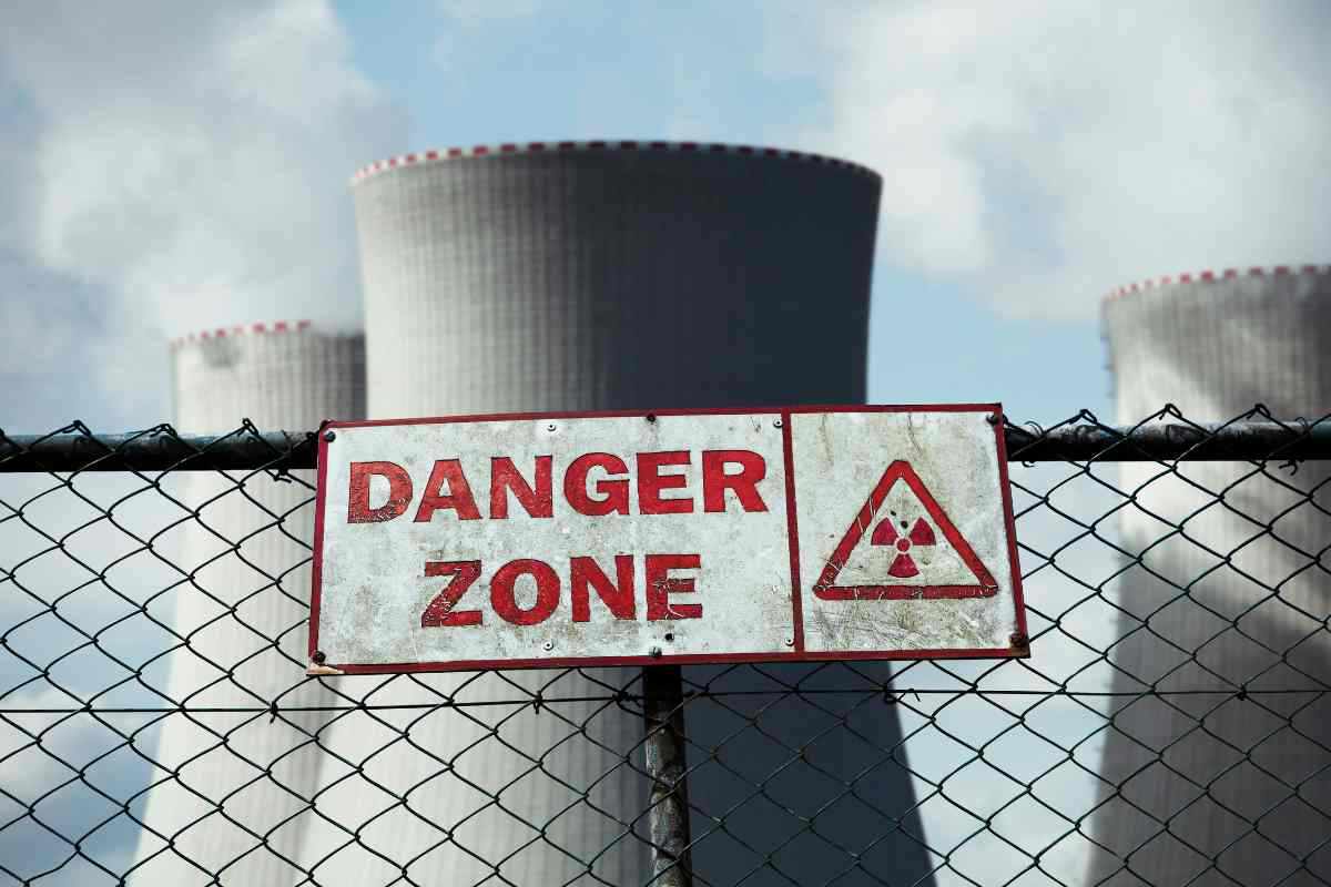 cartello danger zone davanti a una centrale nucleare