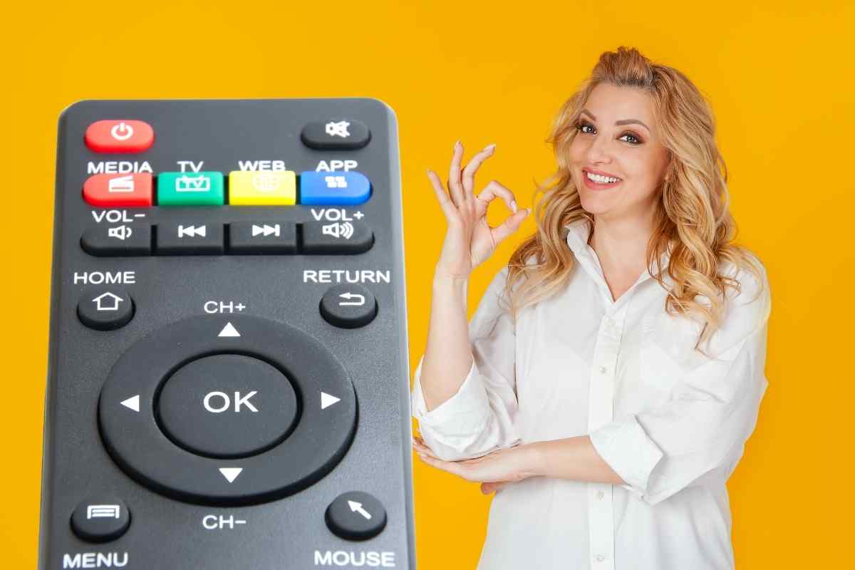 donna che fa il gesto ok e telecomando