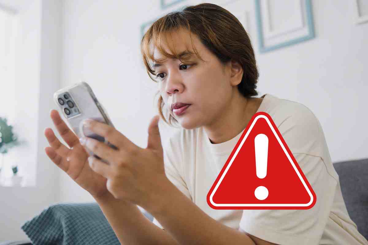 donna con smartphone e icona pericolo