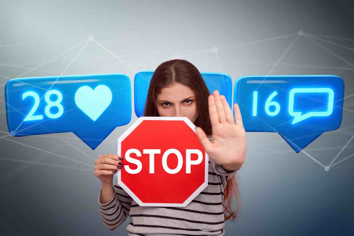 donna con cartello stop e dietro icone social
