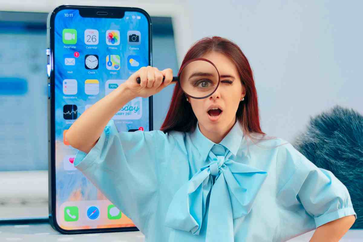 donna con lente di ingrandimento e iphone