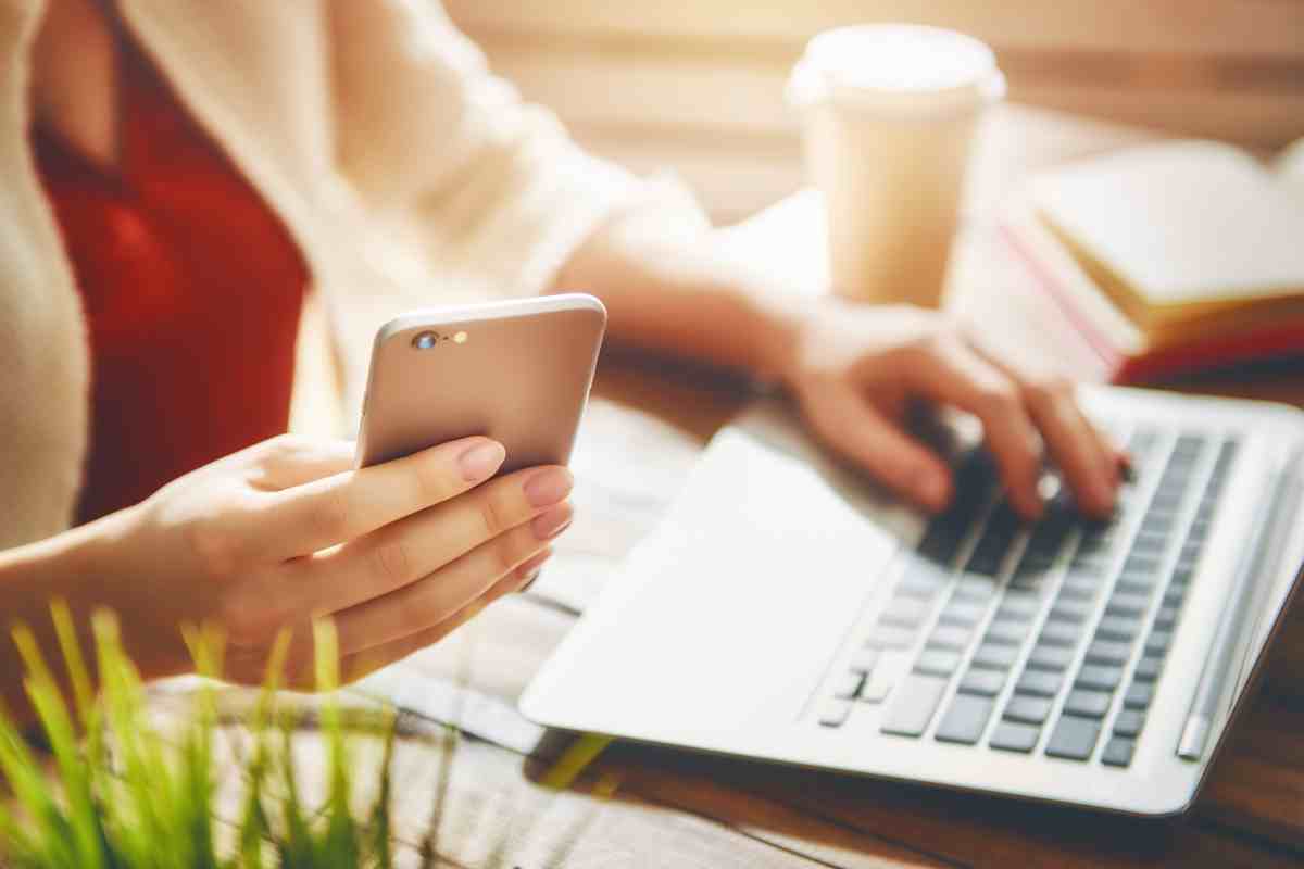 donna al pc con smartphone