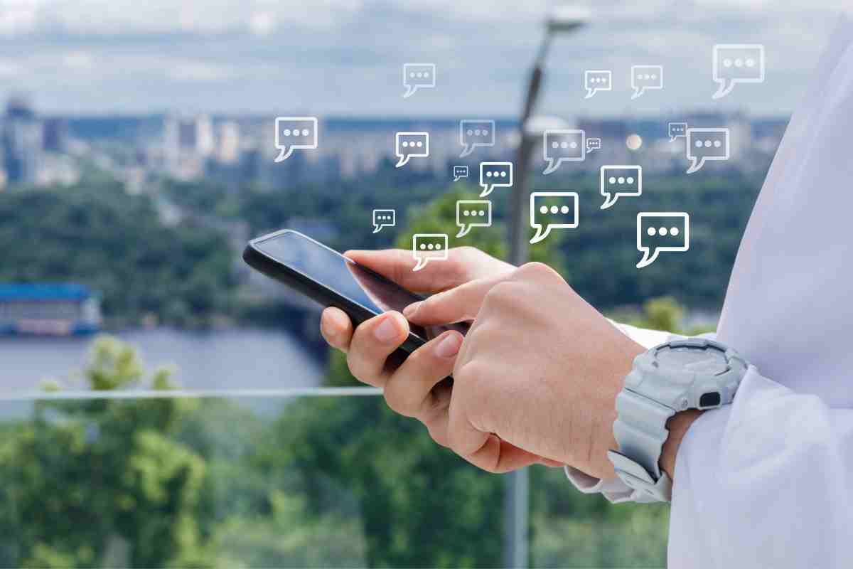 mano su telefono e tante icone di messaggini