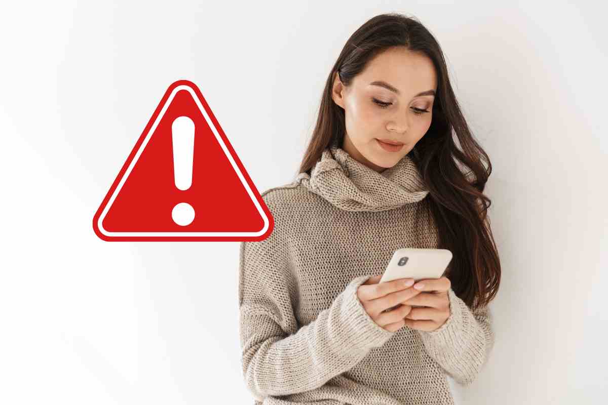 donna con telefono e segnale di pericolo
