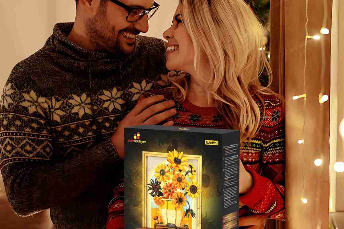 coppia con maglioni di natale e scatola di costruzioni