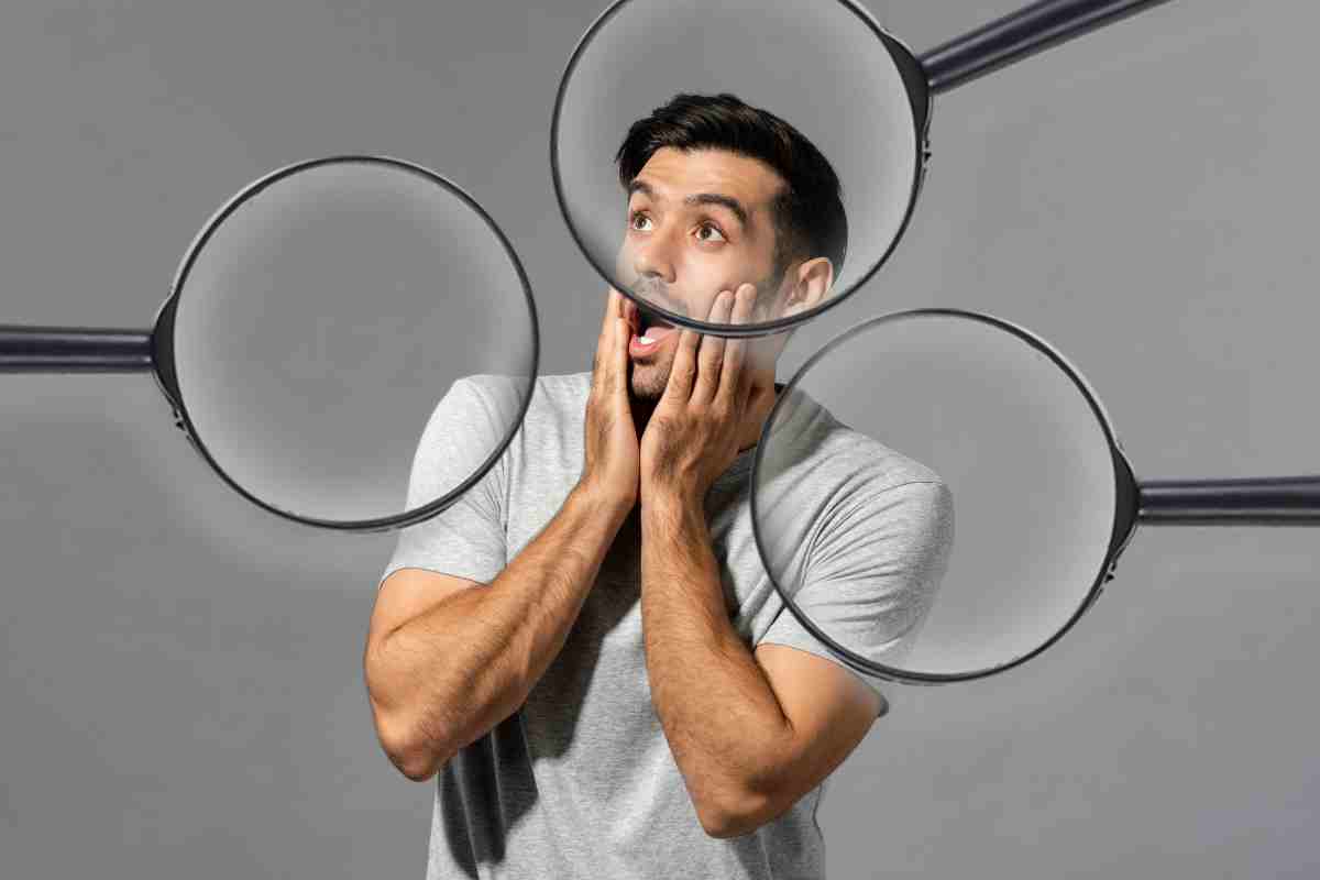 uomo sorpreso con lenti di ingrandimento addosso