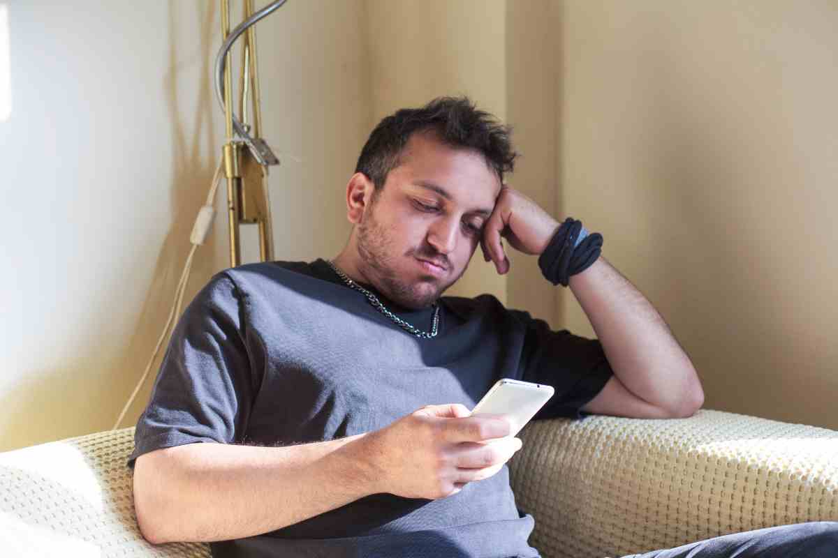 uomo triste con telefono
