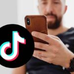 uomo con telefono e logo tiktok