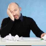 uomo alla scrivania sconvolto